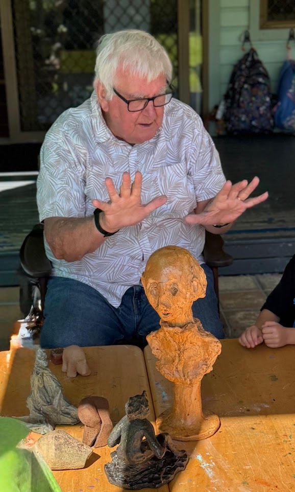 A Grand Friend holding a clay bust with children